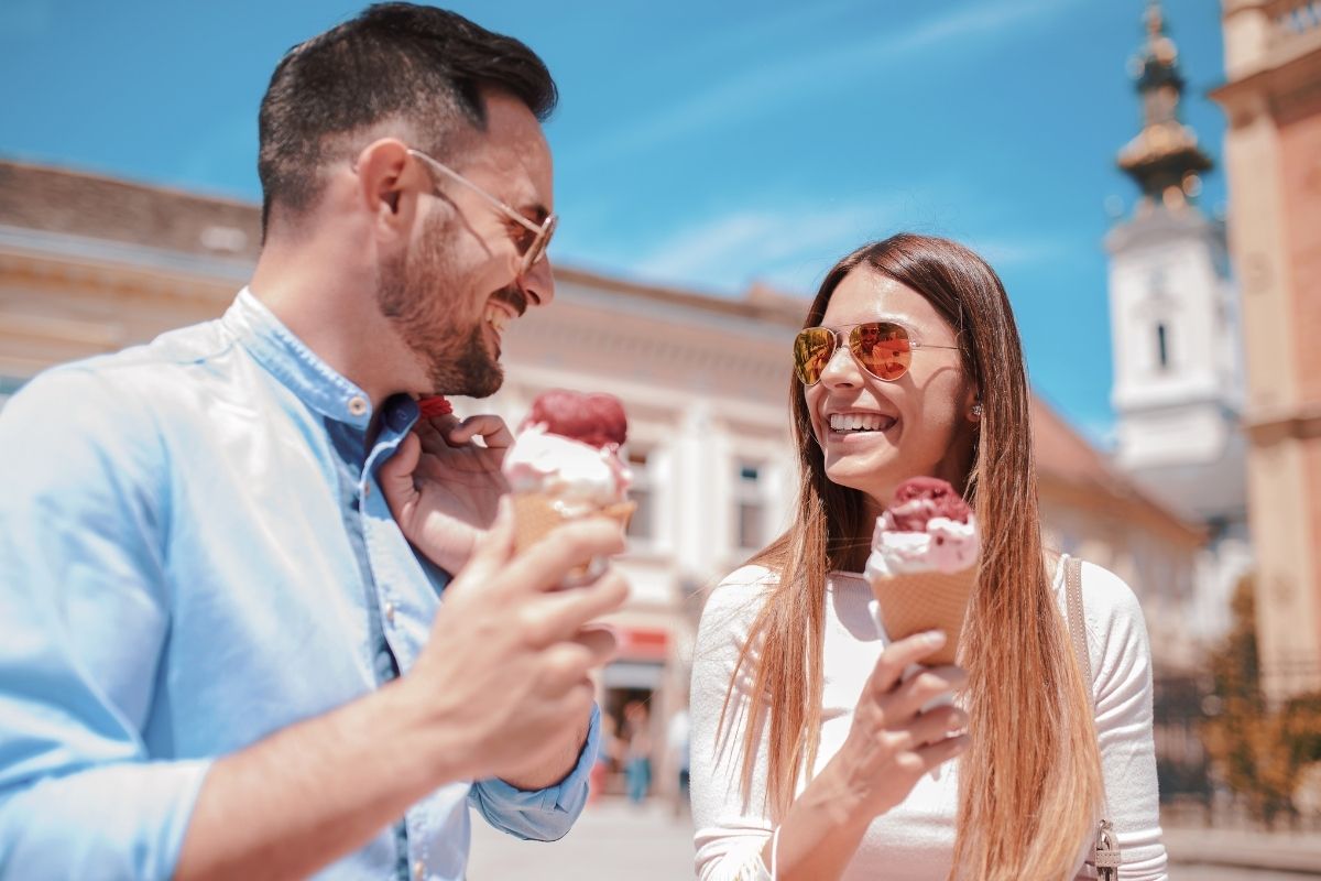 two people looking at each other eating ice cream