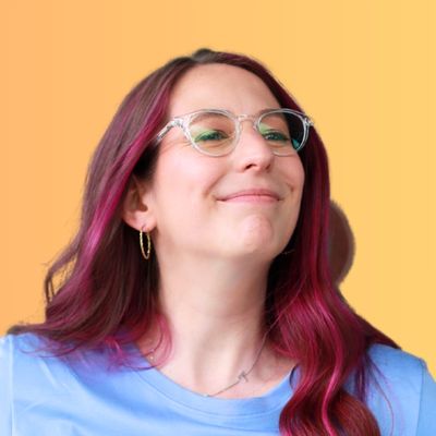 Portrait of Tamara, Certified Life Coach, smiling with pink highlights in her hair, wearing glasses and a blue top, on a yellow background with the text Certified Life Coach below.