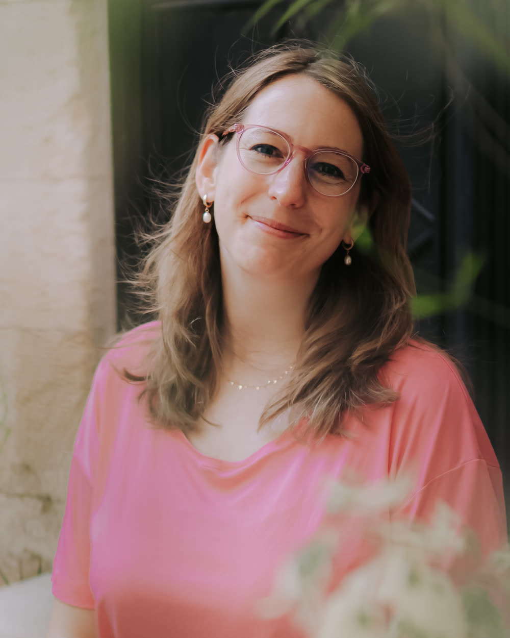 Tamara smiling calmly at the camera in a pink t-shirt